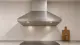 Edelstahl-Dunstabzugshaube über einem Induktionskochfeld mit sichtbaren Metallfettfiltern an der Unterseite